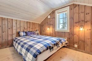 a bedroom with wooden walls and a bed in a room at Gaustablikk hytta ski-in ski-out in Gaustablikk