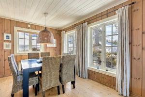 a dining room with a table and chairs and windows at Gaustablikk hytta ski-in ski-out in Gaustablikk