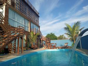 a swimming pool in front of a building with a resort at Pousada Jolie Maison in São Francisco do Sul