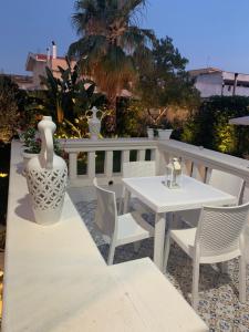 a white table and chairs and a vase on a patio at B&B Palma Salentina in Lizzano