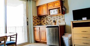 a small kitchen with a sink and a microwave at Acropolis Oceanfront Resort in North Wildwood