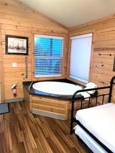 bagno con vasca in una camera con pareti in legno di Westport Inn Cabins a Westport