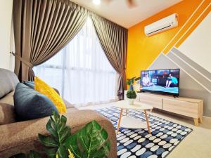 a living room with a couch and a tv at Astetica Residences 100mbps Wifi Netflix in Seri Kembangan