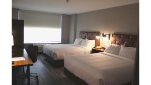 a hotel room with two beds and two lamps at Sunbridge Hotel & Conference Centre Sarnia in Sarnia