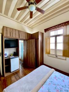 a bedroom with a bed and a ceiling fan at STUDIO 53 in Diamantina