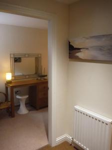 a bathroom with a desk and a mirror at Old Templars Cottage in Spittal