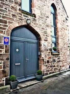 een blauwe deur aan de zijkant van een bakstenen gebouw bij Old Templars Cottage in Spittal