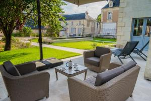 une terrasse avec des chaises, une table et un parasol dans l'établissement La Dixmeresse, à Restigné