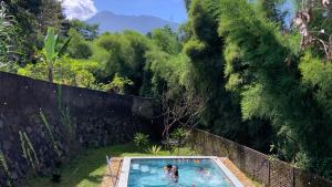 two people in a swimming pool in a garden at Villa Kay Kay Mountain in Bogor