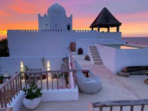 a white building with a sunset in the background at Casa Alkimia Oceanfront in Isla Mujeres