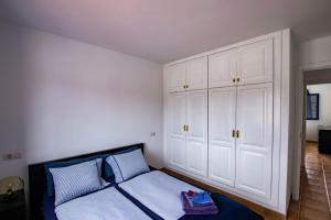 a bedroom with white cabinets and a bed with blue pillows at OCEAN tiny HOUSE en Casa azul in Punta de Mujeres