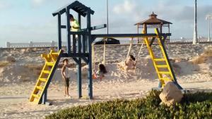 馬特魯港的住宿－شاليهات بورتو مطروح فيو بحر Porto Matrouh Sea View Families Only，一群儿童在海滩上的游乐场玩耍