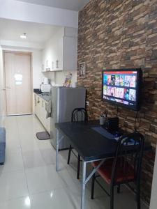 a kitchen with a table and a tv on a brick wall at LIAM's Staycation in Manila