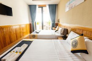 a hotel room with two beds and a television at Sea Night Hotel in Phan Thiet