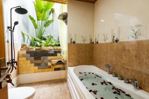 baño con bañera, aseo y planta en Sea Night Hotel en Phan Thiet