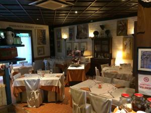 a dining room with white tables and white chairs at Il Podere Del Convento in Villorba