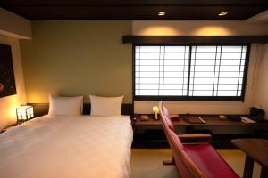 京都京都高濑川别邸的一间卧室，配有一张床、一张书桌和一扇窗户