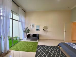 1 dormitorio con cama y alfombra verde en Qaseh Guest House - for Malay only, en Segamat