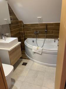 a bathroom with a tub and a toilet and a sink at Mountain Villa Zlatibor in Zlatibor
