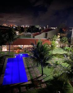 a swimming pool with blue lighting at night at Apartamento Taiba Kite Beach Vista Mar in Taíba