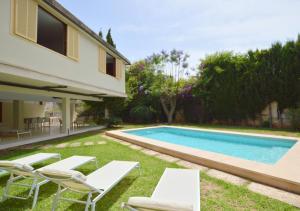 un patio trasero con piscina, sillas y una casa en Villa Palma, en Palma de Mallorca