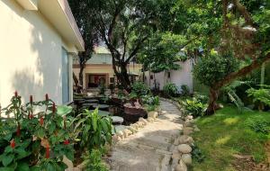 un jardín con plantas y una pasarela junto a una casa en Vạn Huệ Homestay Bình Dương, en Thuan An