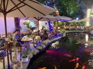 um restaurante com um lago de carpas à noite em Vạn Huệ Homestay Bình Dương em Thuan An