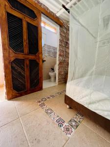 a bedroom with a wooden door and a toilet at Posada Gallinas in Palomino