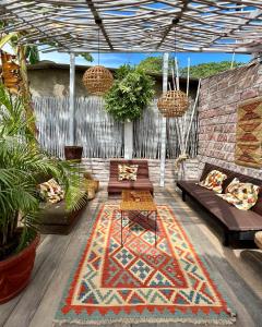 a patio with two couches and a rug at Posada Gallinas in Palomino