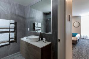 クイーンズタウンにあるQuest Queenstown Apartments Remarkables Parkの洗面台と鏡のあるバスルーム +37枚の写真