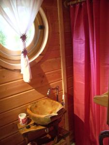 a bathroom with a stone sink and a window at Roulottes des Trolls in La Boussac