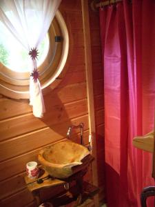 baño con lavabo de piedra y ventana en Roulottes des Trolls, en La Boussac