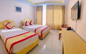 a hotel room with two beds and a television at Khách sạn Sunrise Ninh Thuận in Thôn Dư Khánh