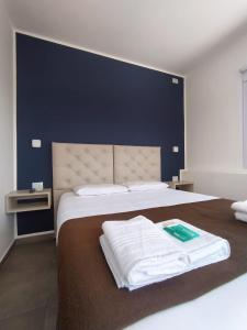 a bedroom with a large bed with a blue wall at Hotel Astoria by CPH in Villa Carlos Paz