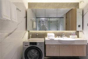 een badkamer met een wasmachine en een wastafel bij Cresasia Residence in Chengdu