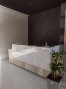 a bathroom with a large marble tub with a potted plant at Hotel Astoria by CPH in Villa Carlos Paz