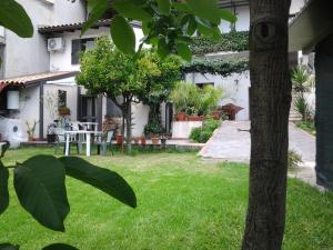 a house with a yard with a table and chairs at Mamma Etna in Pedara