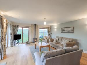 a living room with a couch and a tv at South Milton Cottage in Glenluce
