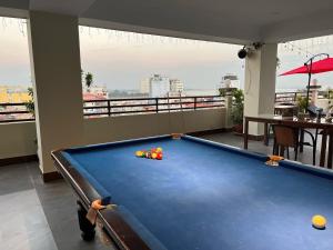 a pool table in a room with a balcony at Queenwood Hotel in Phnom Penh