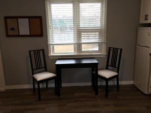 une cuisine avec une table et deux chaises ainsi qu'une fenêtre dans l'établissement Altona Hotel, à Altona