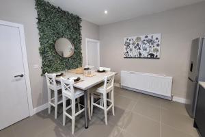 a dining room with a white table and chairs at Kepler Residence Modern 4 Bedroom Property 1 mile from Leeds Centre in Leeds