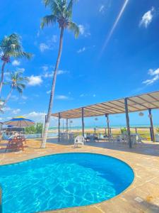 a swimming pool with a view of the ocean and palm trees at Pousada e Restaurante Sombra dos Coqueiros in Trairi