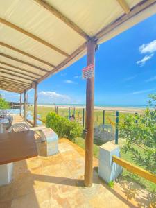 Pousada e Restaurante Sombra dos Coqueiros في ترايري: شرفة مع مقعد وإطلالة على الشاطئ