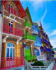 a colorful building with colorful windows and balconies at Plage à 50m Appartement Rêves tranquilles Villa Les Bains de Mers in Mers-les-Bains