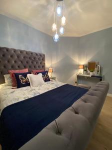 1 dormitorio con 1 cama grande y cabecero grande en Lovely 3 bed with jacuzzi, close to airport, driveway, wifi, en Edimburgo