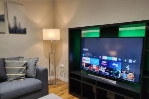 a living room with a large flat screen tv at Kepler Residence Modern 4 Bedroom Property 1 mile from Leeds Centre in Leeds