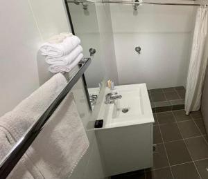 La salle de bains est pourvue d'un lavabo, d'un miroir et de serviettes. dans l'établissement Gulgong Motel, à Gulgong