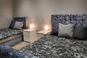 a bedroom with a bed and a headboard with a lamp at Kepler Residence Modern 4 Bedroom Property 1 mile from Leeds Centre in Leeds