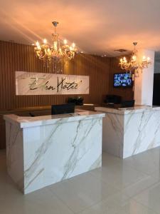 a lobby with white marble counters and a chandelier at Éden Hotel in Rio Verde