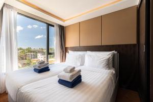 a hotel room with a bed with towels on it at Aristo 1 Phuket in Phuket Town